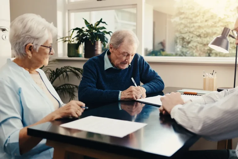 Couple de seniors signant des documents avec un conseiller
