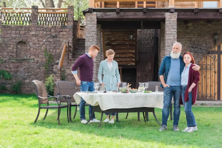 Famille réunie autour d'une table dans le jardin d'une maison en brique