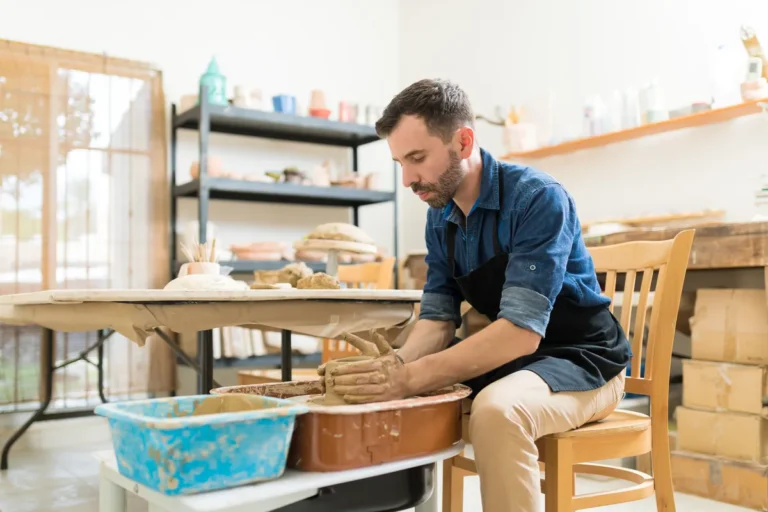 Artisan potier façonnant l'argile dans son atelier, petite entreprise financée par microcrédit