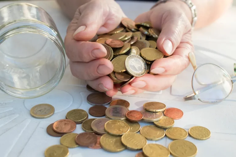 Mains comptant des pièces en euros sur une table