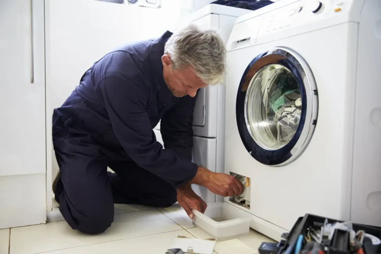 Réparateur intervenant sur une machine à laver en panne