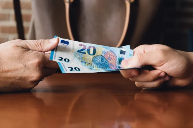 Billet de vingt euros passant d'une main à l'autre, prêt entre particuliers