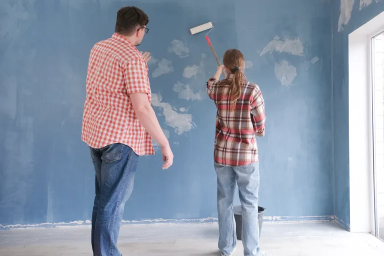 Couple repeignant un mur au rouleau pour améliorer son logement