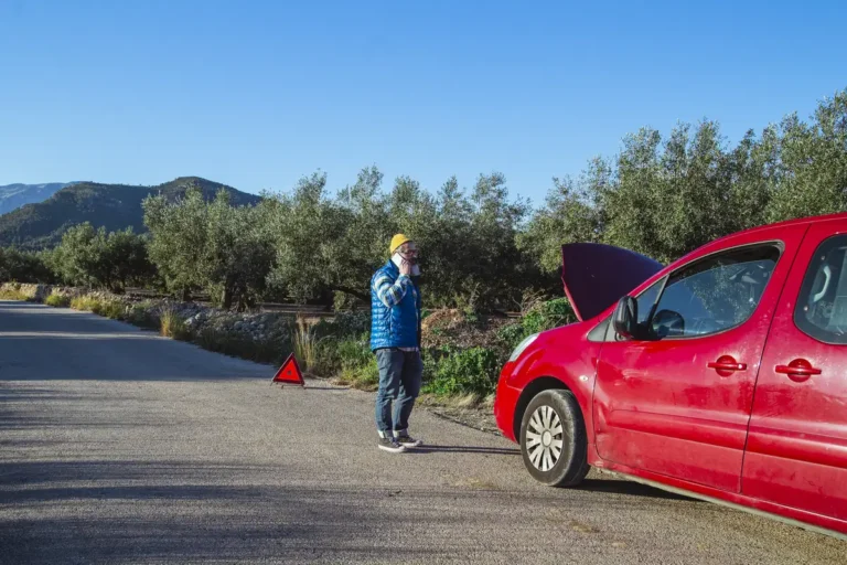Automobiliste en panne téléphonant au bord de la route, dépense imprévue