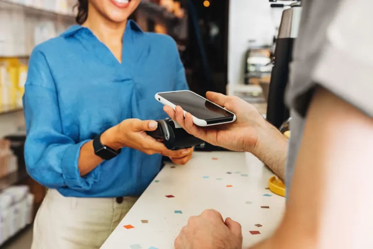 Client payant avec son smartphone au comptoir d'un café