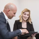 Femme et homme en rendez-vous de travail autour d'une tablette