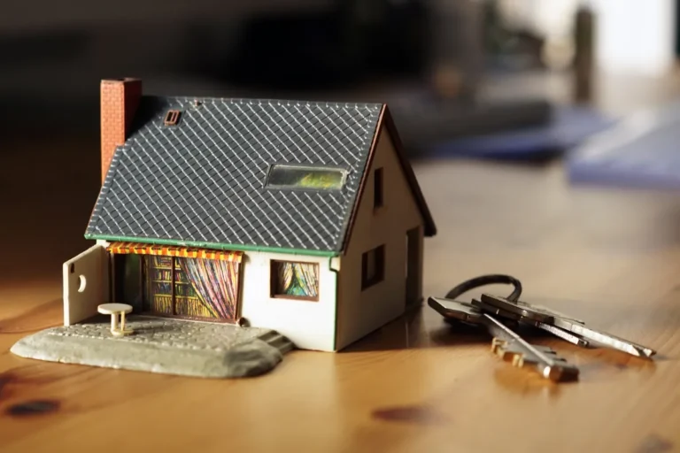 Maquette de maison posée sur une table à côté d'un trousseau de clés