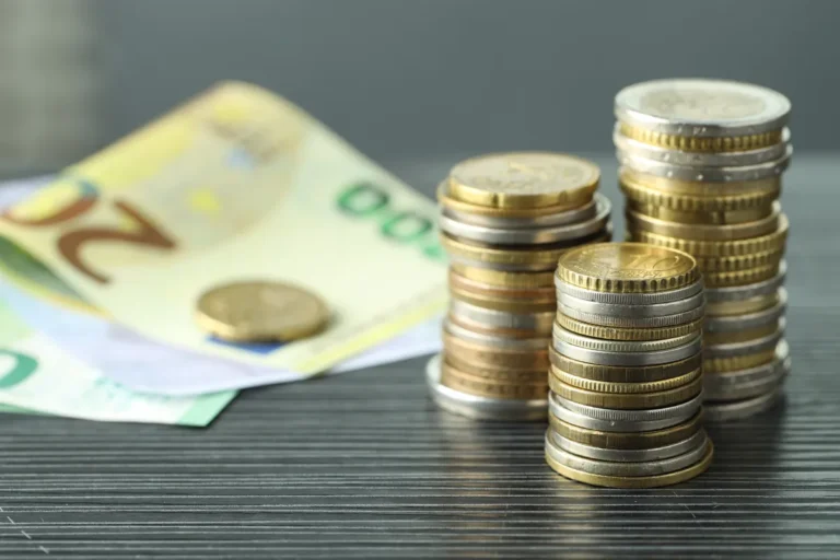 Piles de pièces en euros devant des billets, épargne sur livret