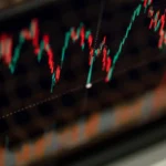 Gros plan sur un graphique boursier en chandeliers affiché sur un écran de trading
